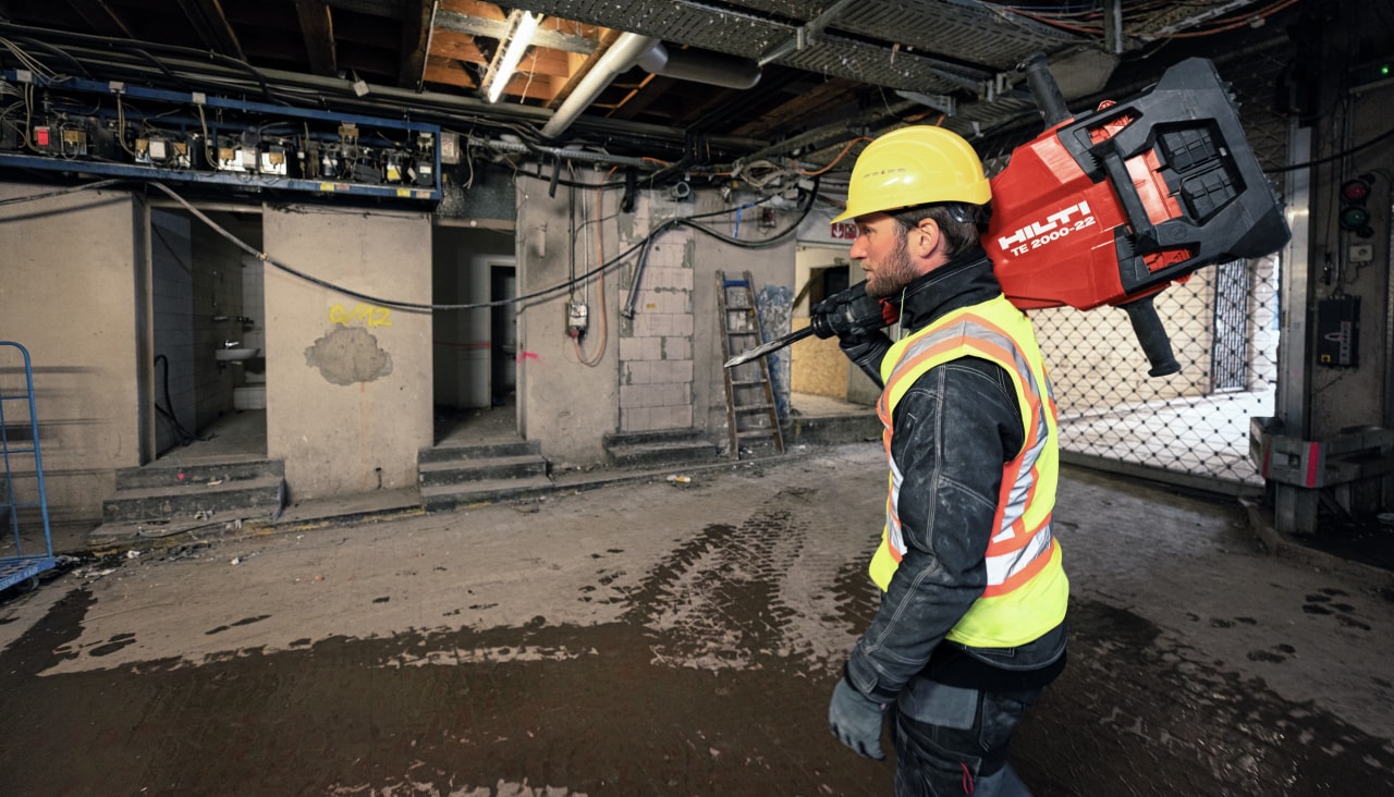 Worker carrying the TE 2000-22 Cordless jackhammer on the jobsite