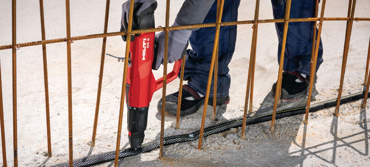 Installing watersealing hose with powder-actuated tool DX 6-F8 and nail with steel washer