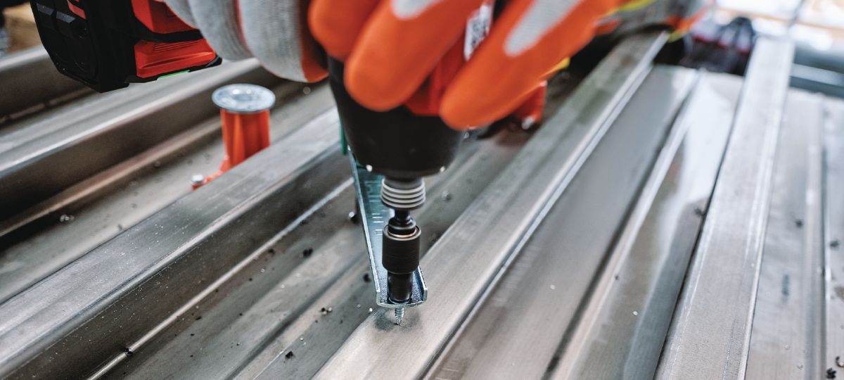 Cropped application image of Construction worker using SID 6-22 with a KCM-MD Kwik Cast combo bit to install KCCM-MD cast-in anchors. Golden, CO. 2024.