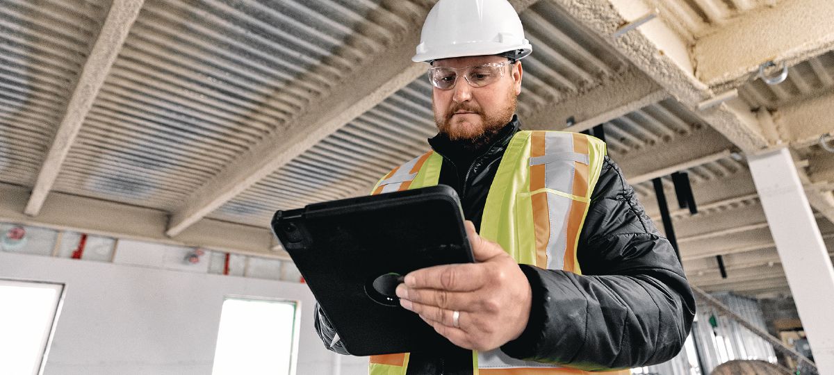 Cropped image of operations manager on a jobsite looking at a tablet.