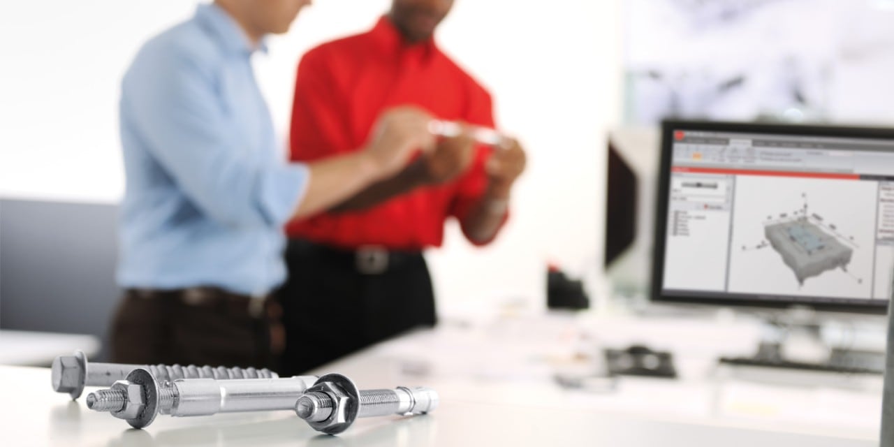 Two engineers discussing fasteners in front of a computer screen